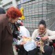 Holocaust survivors hand gift baskets to asylum seekers